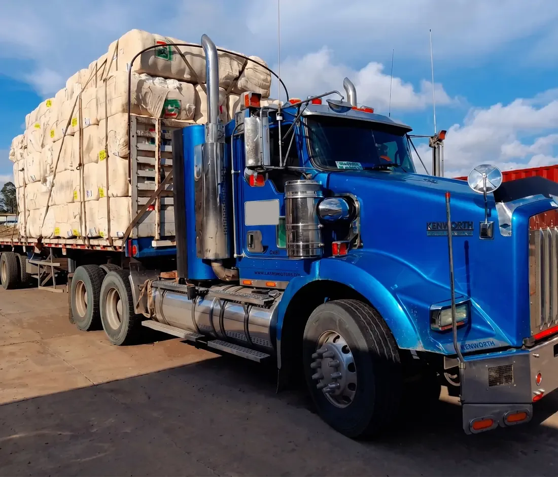Tractocamión Kenworth azul de Caritrans cargado con pacas de algodón