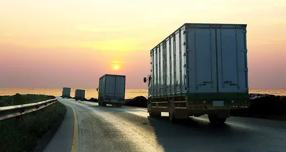 Camiones en carretera al atardecer